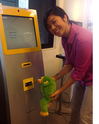 Victoria feeding a Bitcoin ATM machine with a fifty-dollar note back in 2014